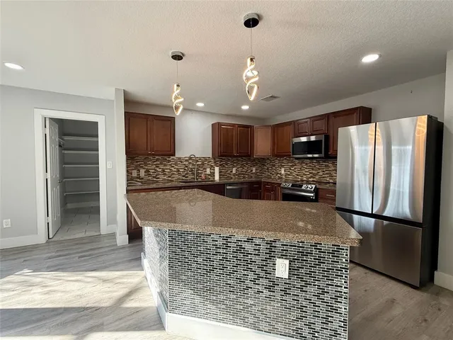 a large kitchen with kitchen island a cabinetry and refrigerator