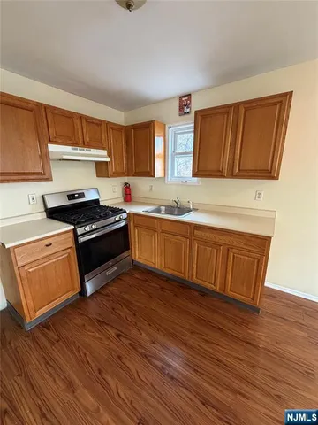 a kitchen with wooden floors and wooden cabinets