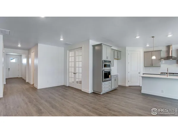 a kitchen with a sink a stove a refrigerator and white cabinets