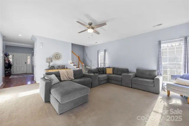a living room with furniture and a view of kitchen
