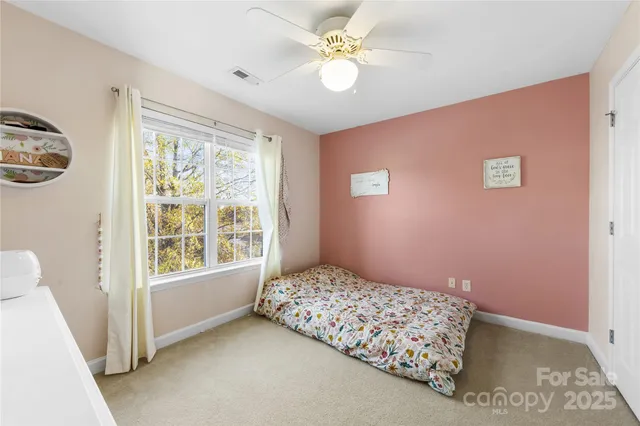 a bedroom with a bed dresser and wooden floor