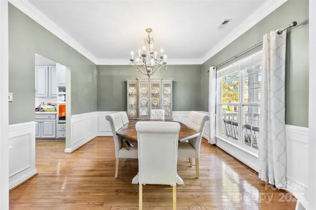 a view of a dining room with furniture wooden floor and chandelier