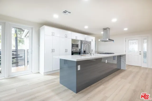 a large kitchen with kitchen island a sink stainless steel appliances and cabinets