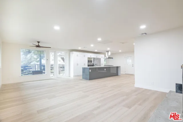 a large white room with kitchen island and a large window
