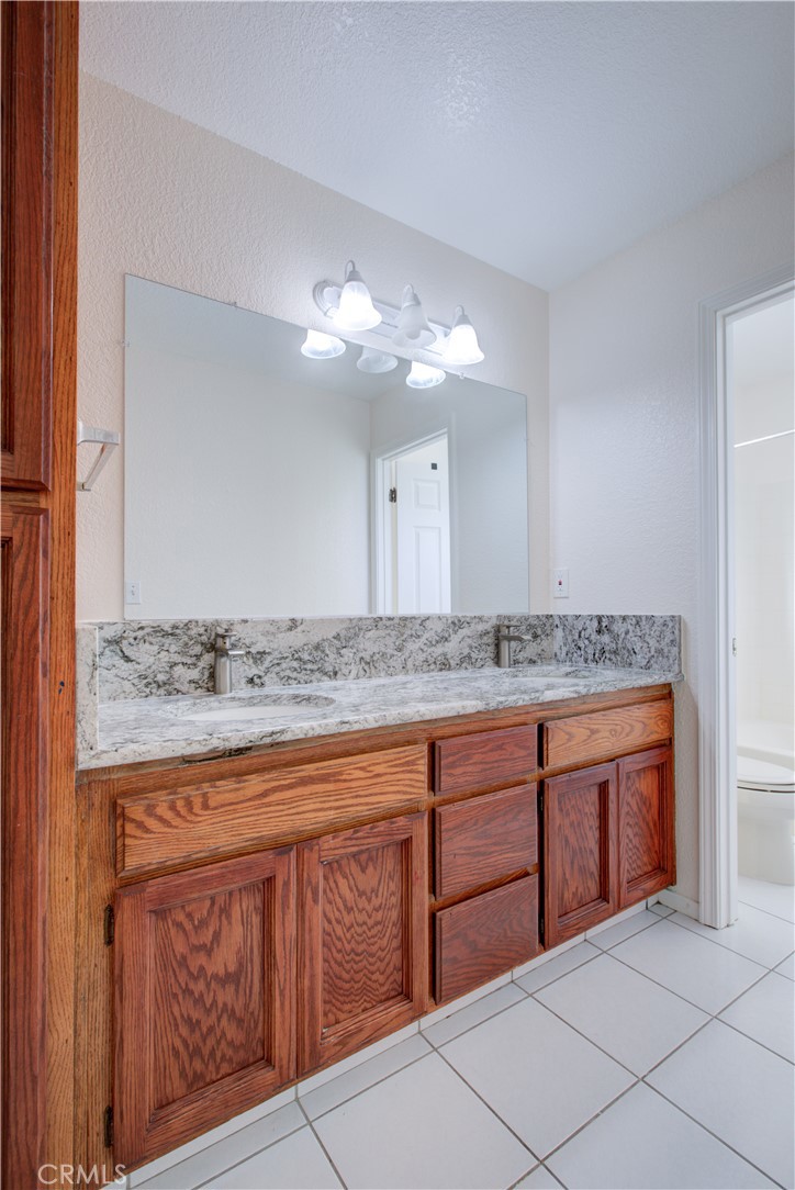 2341 Mesquite Court Merced, CA 95348 - Photo 12 of 17 a bathroom with a granite countertop double vanity sink and mirror