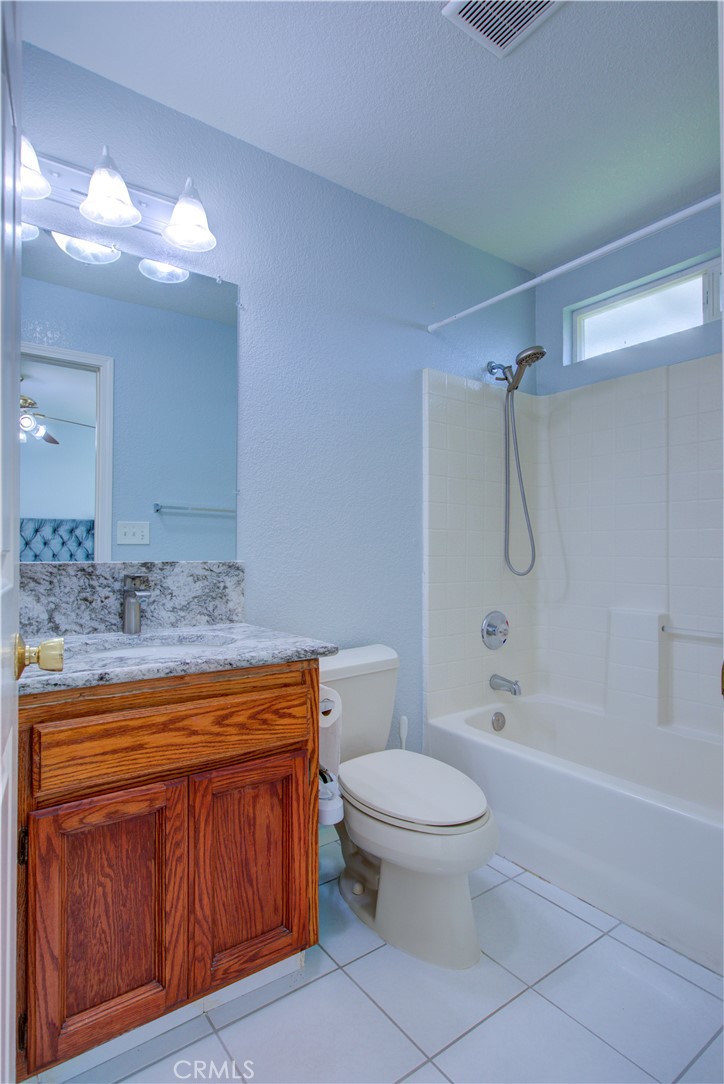 2341 Mesquite Court Merced, CA 95348 - Photo 6 of 17 a bathroom with a granite countertop toilet a sink and a bathtub