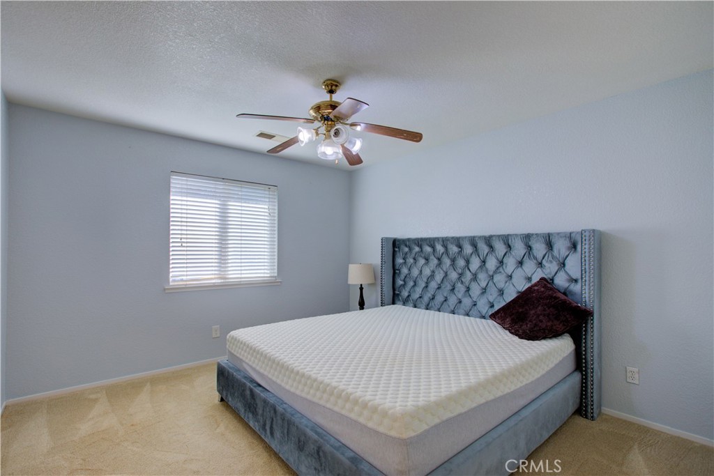 2341 Mesquite Court Merced, CA 95348 - Photo 7 of 17 a bedroom with a bed and a chandelier