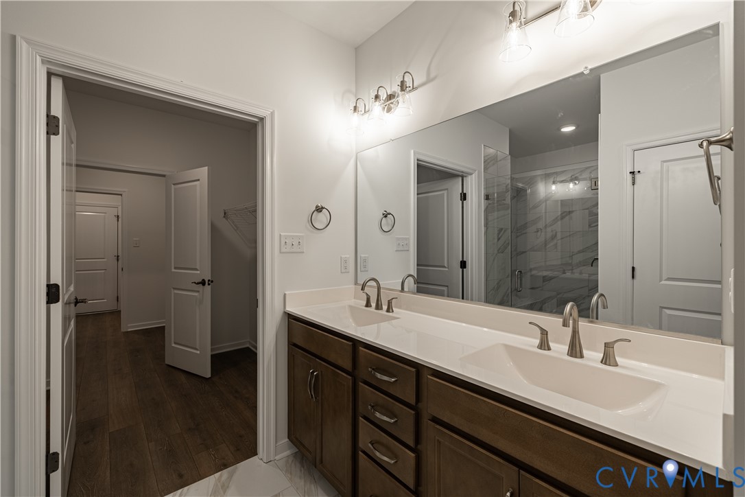 6715 Mayland Ridge Lane Moseley, VA 23120 - Photo 7 of 14 a bathroom with a double vanity sink a mirror and a shower