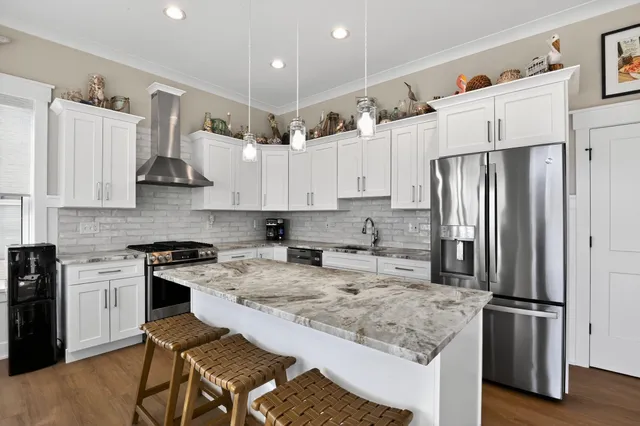 a kitchen with stainless steel appliances granite countertop a refrigerator stove microwave and sink