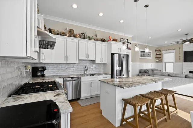 a kitchen with kitchen island granite countertop a sink stove and refrigerator