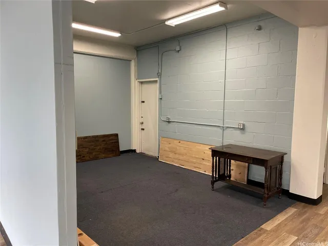 a view of an empty room with window and hardwood floor