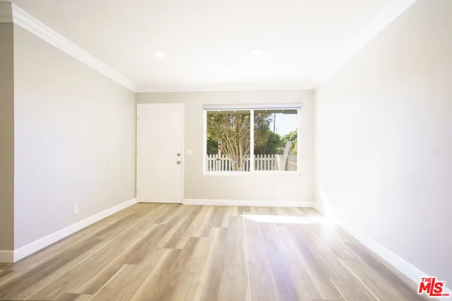 a view of a hallway with wooden floor and a living room