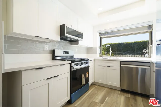 a view of a room with wooden floor and white walls