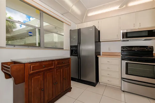 a kitchen with stainless steel appliances granite countertop a refrigerator and a stove