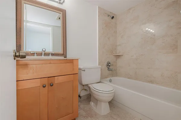 a bathroom with a granite countertop sink mirror vanity and toilet