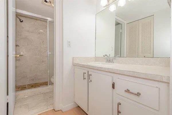 a bathroom with a shower sink and mirror