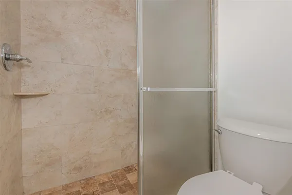 a bathroom with a toilet and a shower