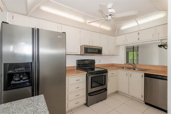 a kitchen with granite countertop a refrigerator stove and sink