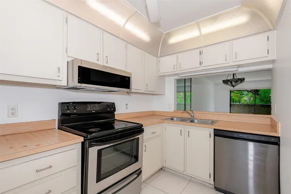 a kitchen with granite countertop a sink stove and cabinets