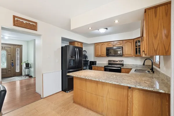 a kitchen with granite countertop a refrigerator and a sink