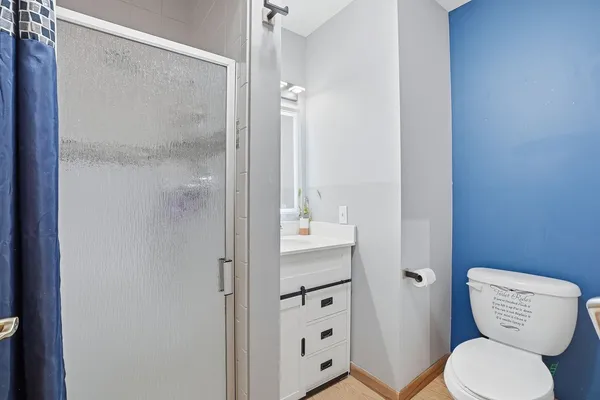 a bathroom with a toilet a sink and shower