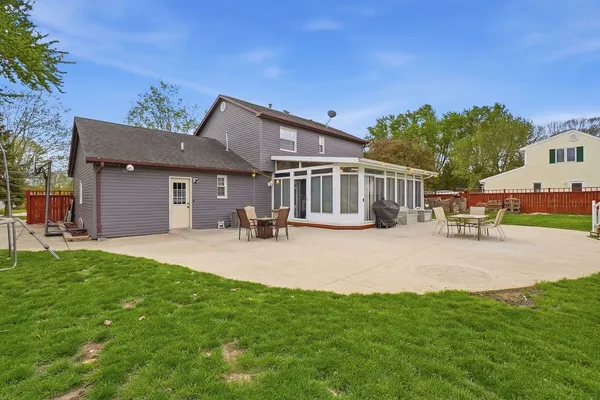 a view of a house with a big yard potted plants and large tree