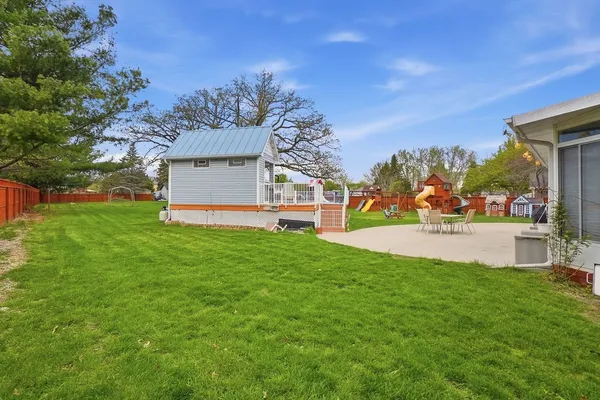 a view of a deck with wooden floor and fence with a large garden