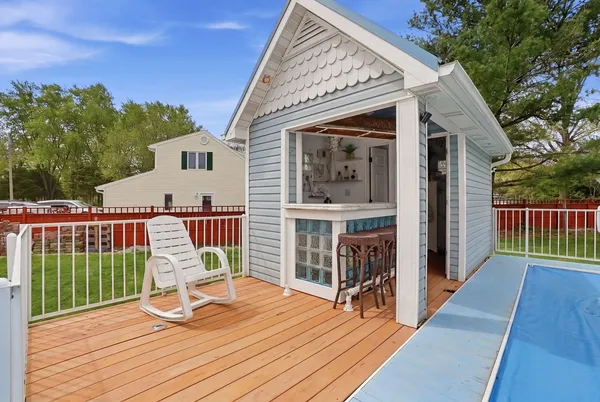 a view of a chair and table on the wooden deck