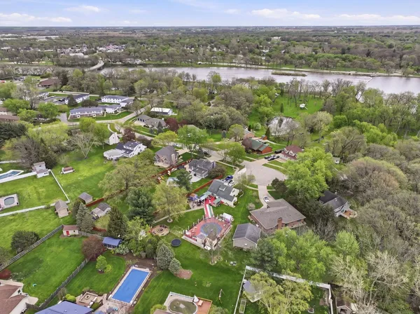 an aerial view of residential houses with outdoor space and trees