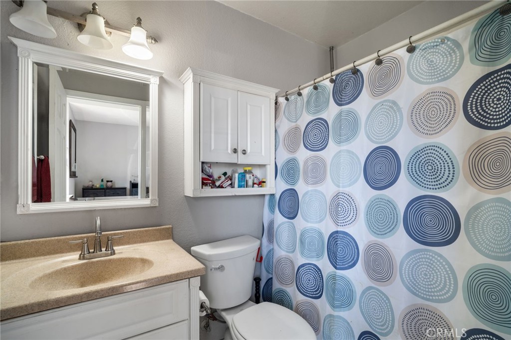 29773 Gifhorn Road Menifee, CA 92584 - Photo 14 of 25 a bathroom with a sink and mirror with toilet