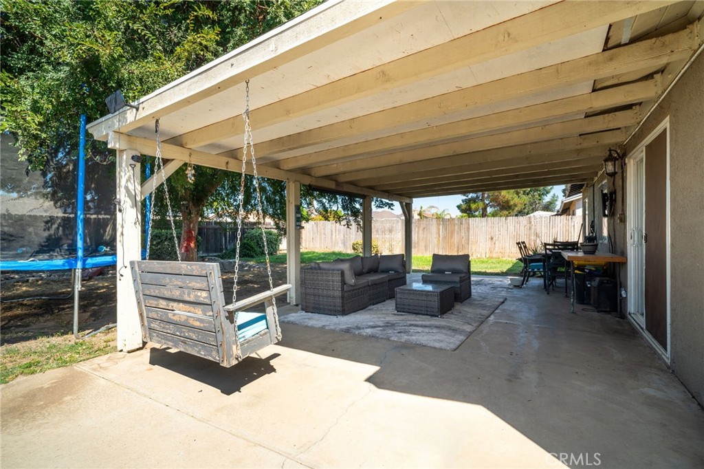 29773 Gifhorn Road Menifee, CA 92584 - Photo 20 of 25 a view of a patio with table and chairs under an umbrella with a large tree