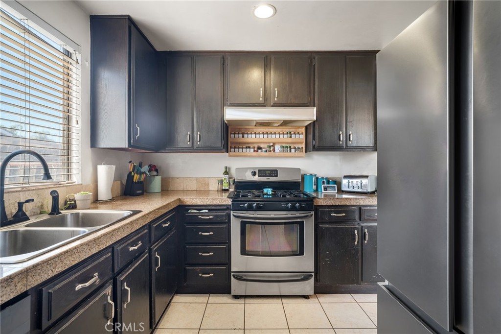 29773 Gifhorn Road Menifee, CA 92584 - Photo 8 of 25 a kitchen with stainless steel appliances granite countertop a stove a sink and a microwave
