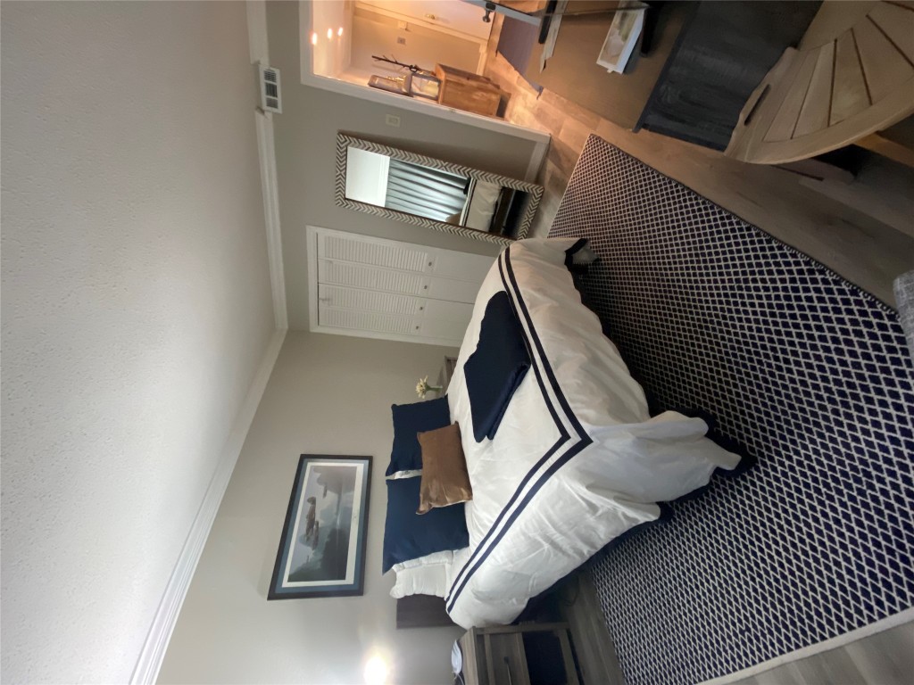 1122 Colorado Street, Unit 1802 Austin, TX 78701 - Photo 5 of 9 a bedroom with a bed lamp on desk and a window