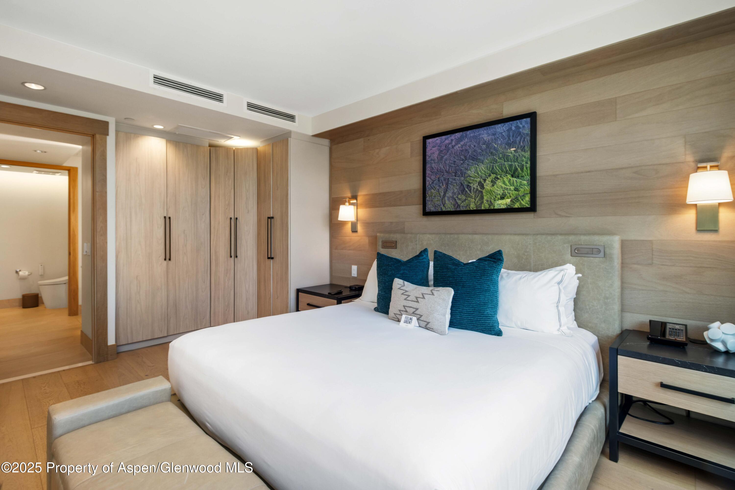 130 Wood Road, Unit 151 Snowmass Village, CO 81615 - Photo 11 of 16 a bedroom with a bed and a painting on the wall