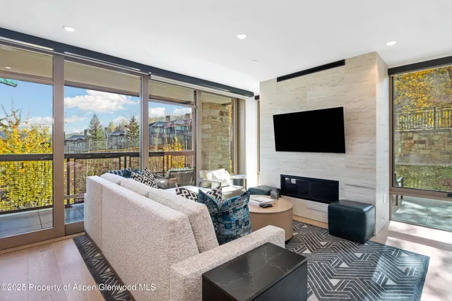 a living room with furniture tv and a floor to ceiling window