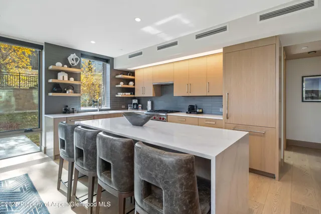 a kitchen with a table chairs sink and cabinets