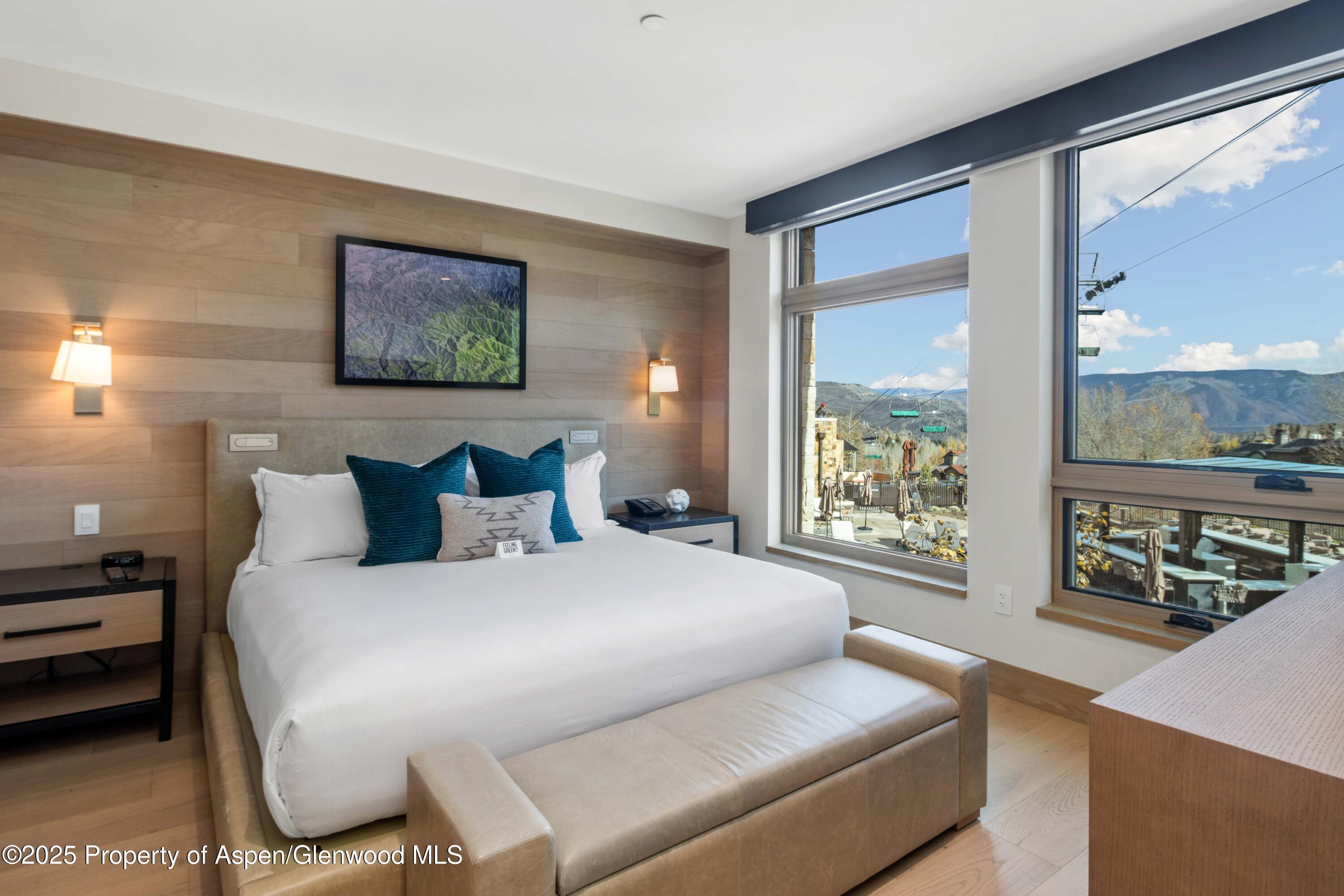 130 Wood Road, Unit 151 Snowmass Village, CO 81615 - Photo 10 of 16 a bedroom with a bed and glass window