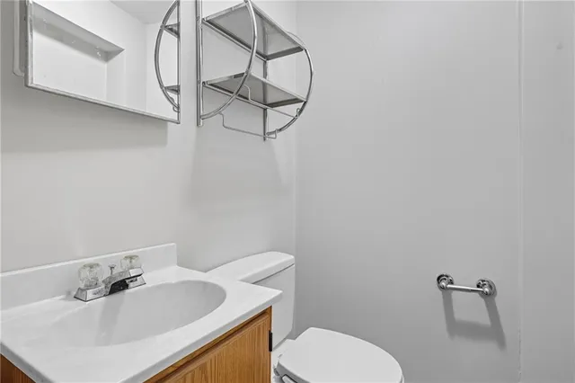 a bathroom with a sink mirror vanity and toilet