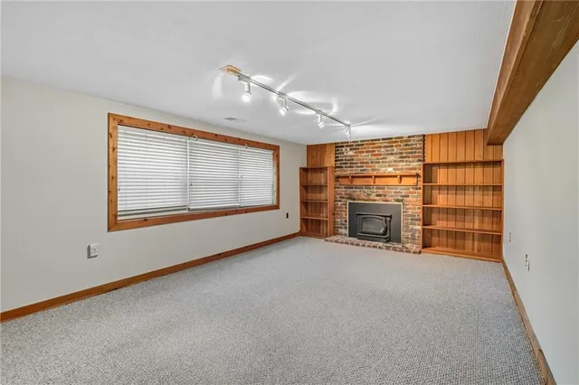 a view of an empty room with a fireplace and a window
