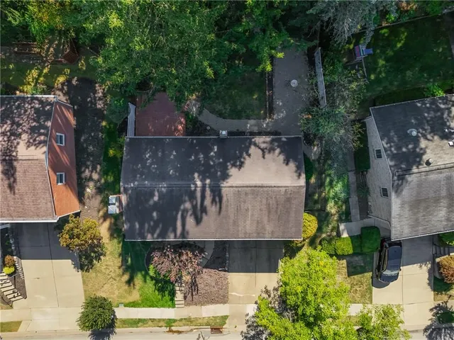 an aerial view of a house with a yard and large tree