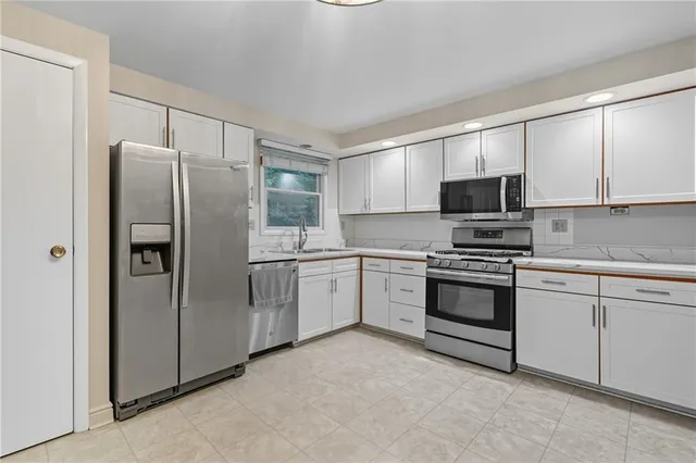 a kitchen with stainless steel appliances a refrigerator stove and microwave