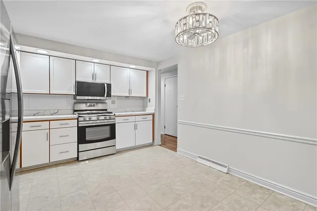a kitchen with a refrigerator and white cabinets