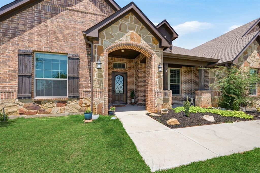 140 Heather Lane Decatur, TX 76234 - Photo 4 of 39 a front view of a house with garden