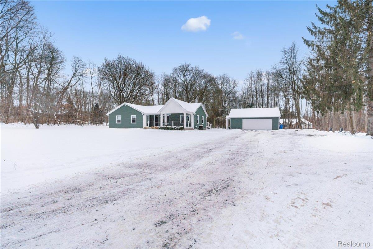 4666 Brighton Road Brighton, MI 48116 - Photo 3 of 37 View of front facade featuring an outdoor structure, view of scattered trees, and a garage