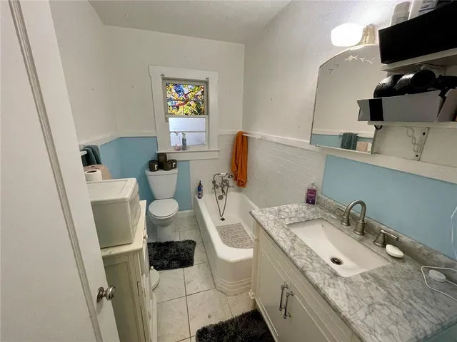 a bathroom with a granite countertop toilet sink and mirror