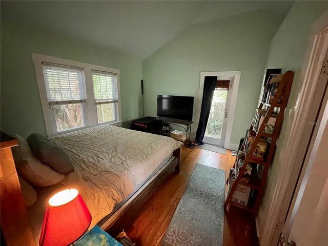 a bedroom with a bed and dresser with mirror