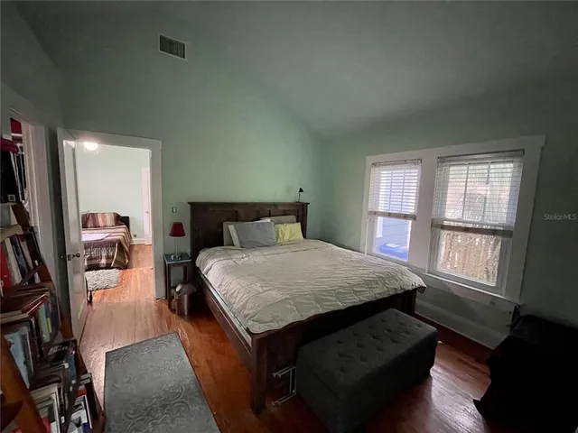 a bedroom with a bed a window and dresser