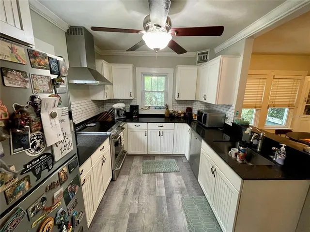 a kitchen with a stove a refrigerator and a window