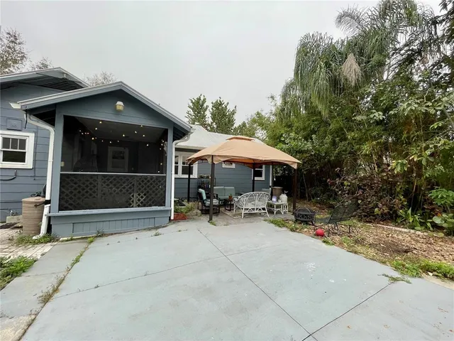 a view of backyard with barbeque grill and outdoor seating