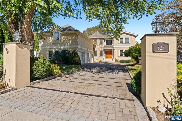 a front view of a house with a yard and potted plants